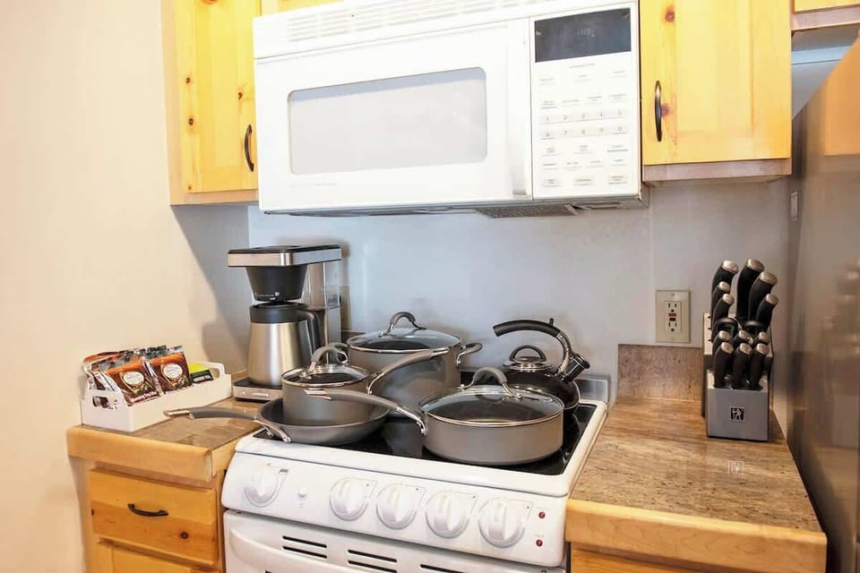 Fully equipped kitchen with brand new cookware set, knives, and coffee machine. 