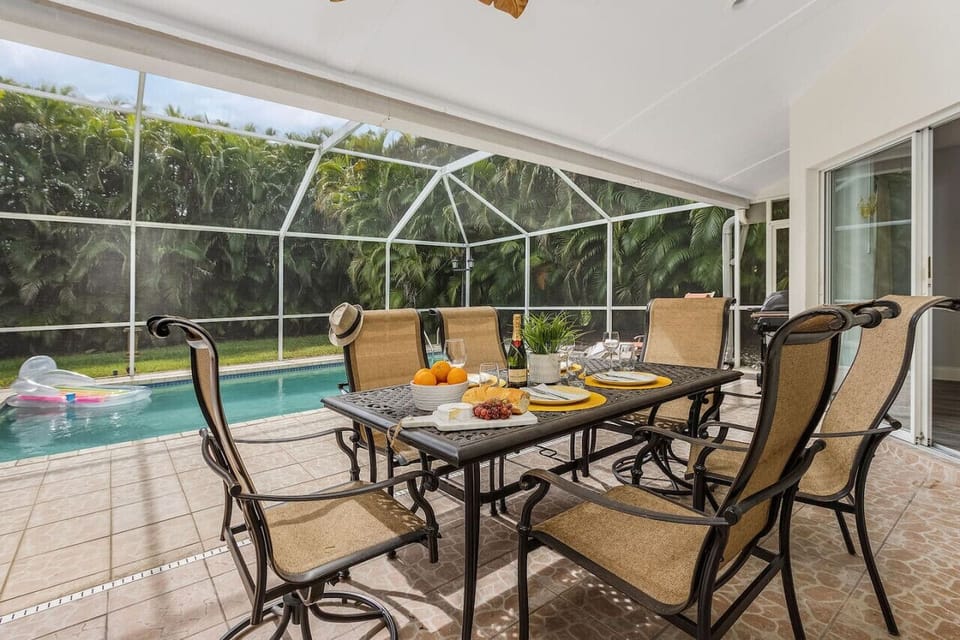 Fully screened pool area with loungers, conversational seating, outdoor dining and a gas grill