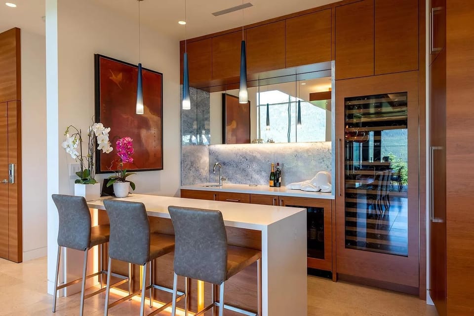 Large bar space with huge wine fridge and seating for 3 located beside dining table