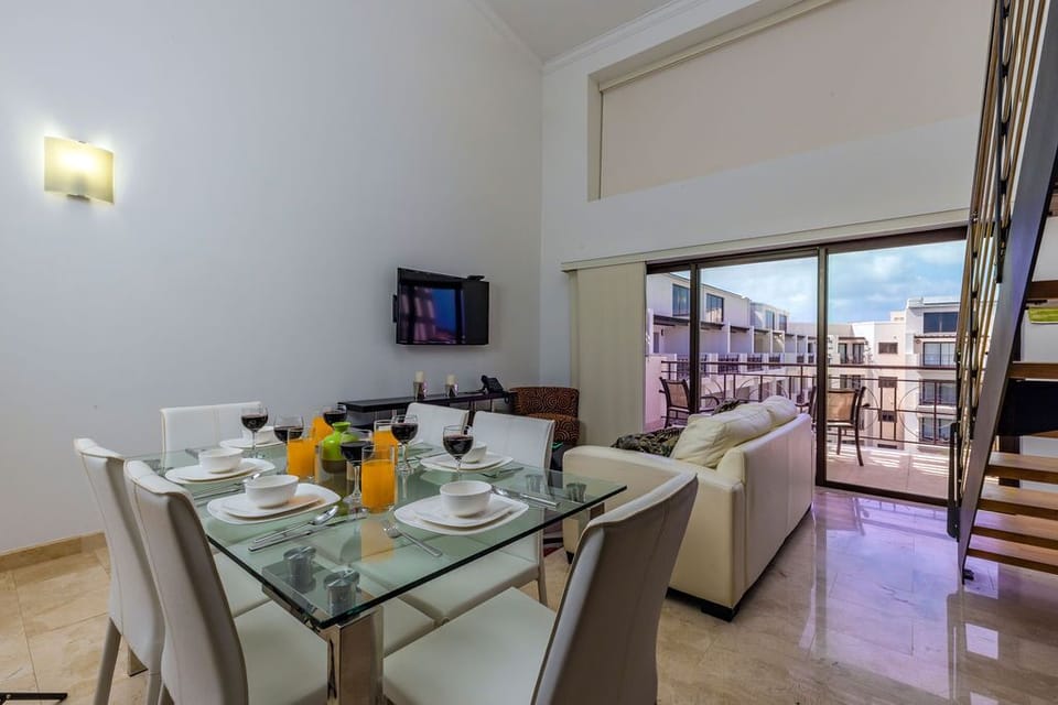 Ample living space with dining table, television, and well-equipped kitchen.
