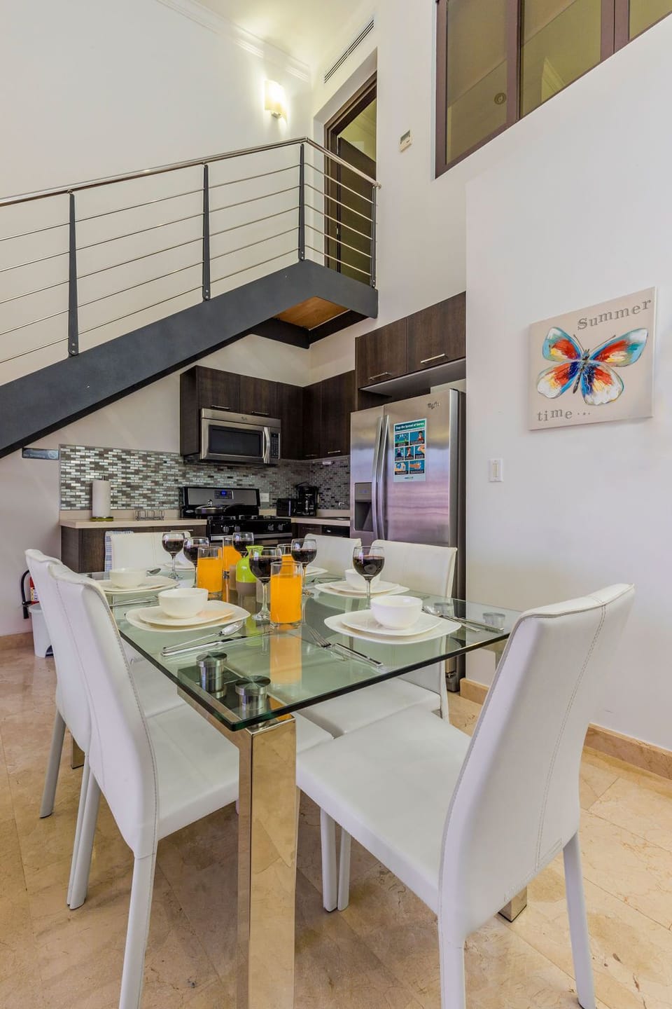 Ample living space with dining table, television, and well-equipped kitchen.