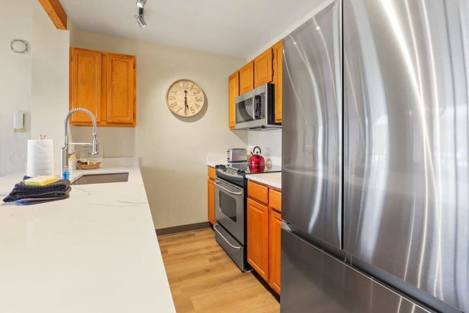 Fully-equipped kitchen with stainless steel appliances, stone countertops and a spacious peninsula that makes for easy serving to the nearby dining area.