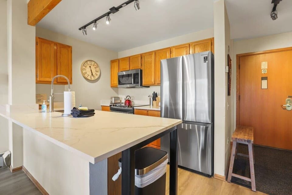 Fully-equipped kitchen with stainless steel appliances, stone countertops and a spacious peninsula that makes for easy serving to the nearby dining area.
