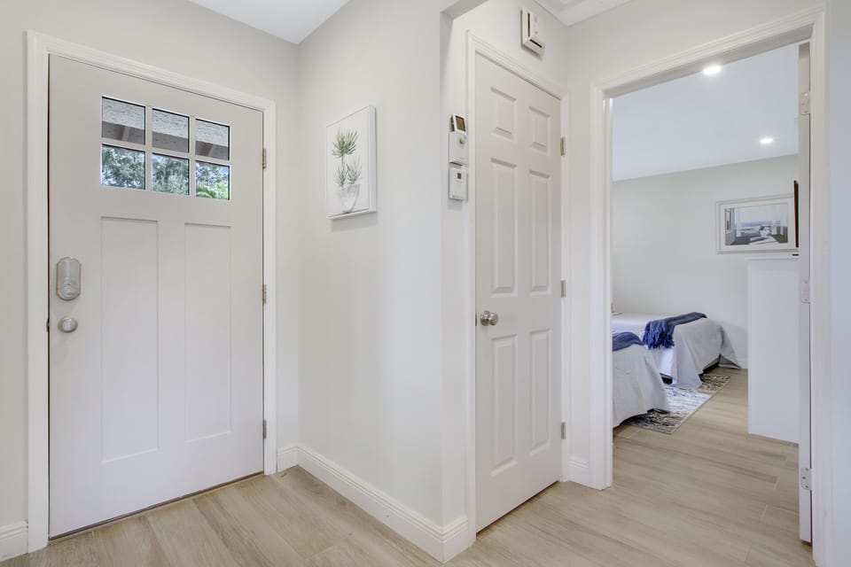 View of front door, laundry closet and guest room from inside the cottage.