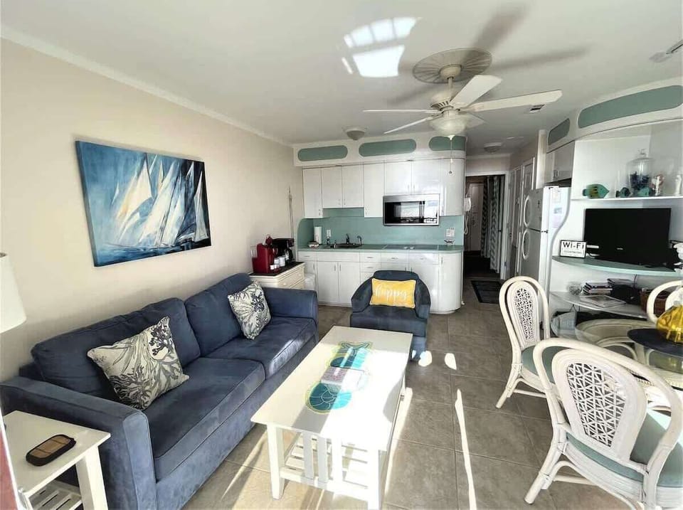 A bright, coastal-inspired living room featuring a comfortable navy blue sofa.