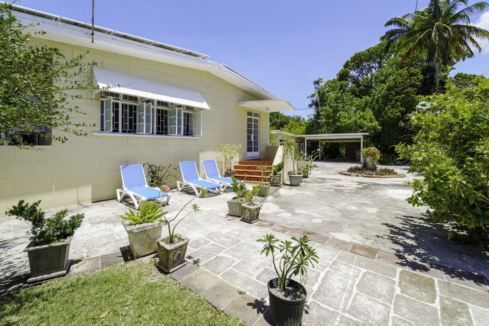Front yard with covered parking on the left of the photo.