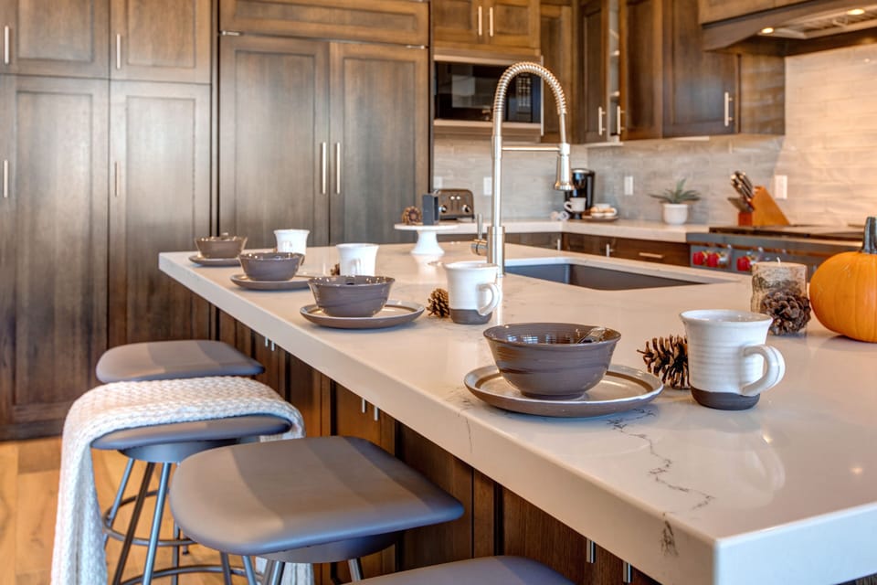 Fully equipped, kitchen with stone countertops, stainless steel appliances with stovetop, fridge, and island