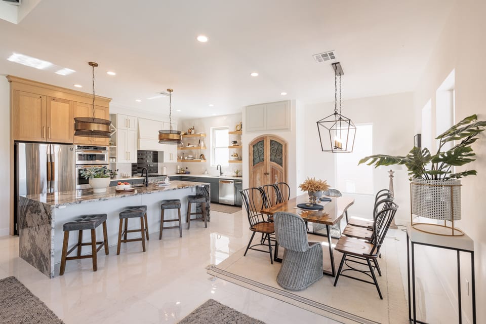 Kitchen & Dining Room View - The kitchen is fully stocked with all the dishes, cookware, baking pans, and cutlery you will need for meal preparations and includes stainless steel appliances and marble counter tops.