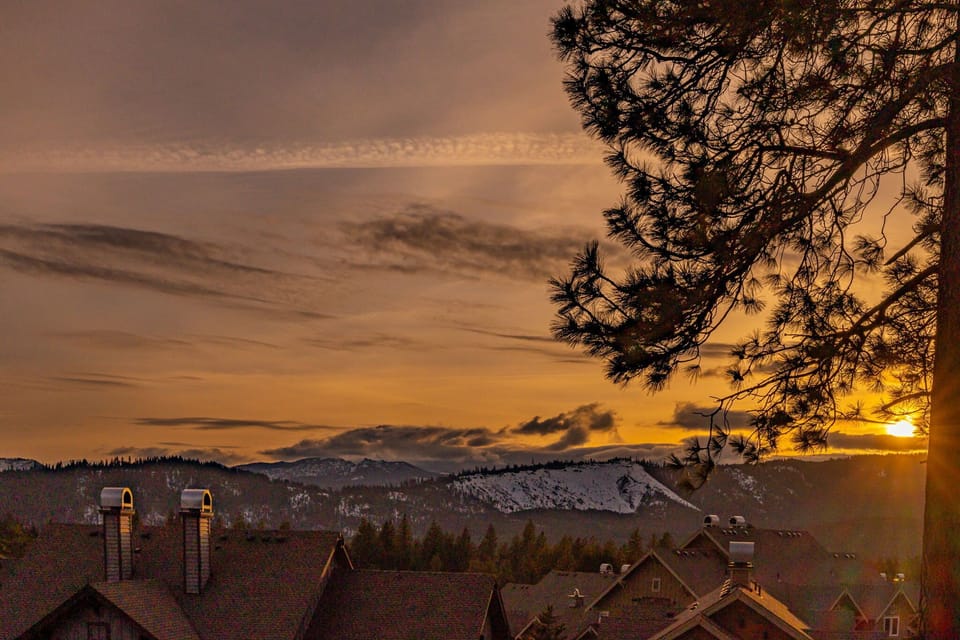Breathtaking sunset over alpine rooftops with layered mountain silhouettes