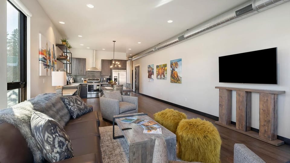 Open concept living room, dining area, and fully stocked kitchen. Living room includes luxury top of the line king sofa sleeper, balcony with gas grill