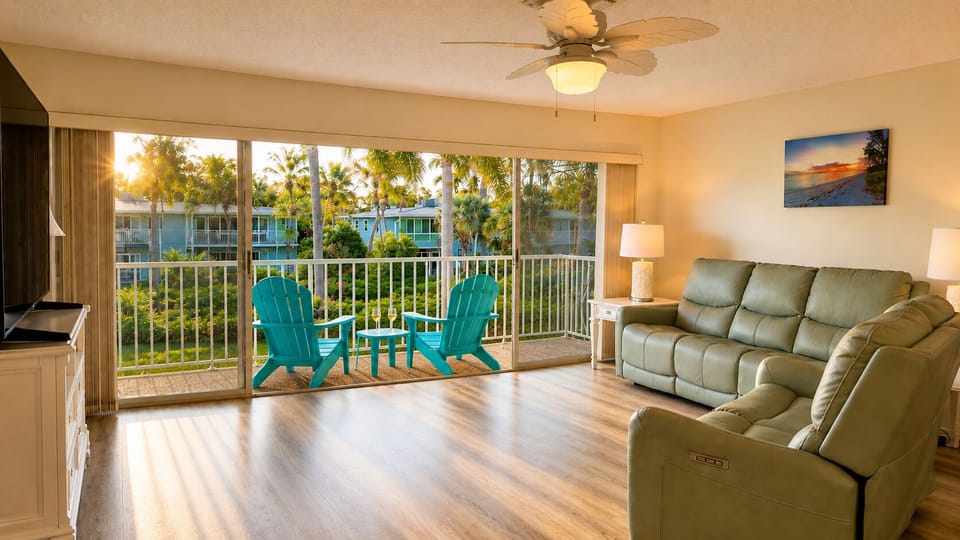 Bright, open living room with balcony access and tropical pool views