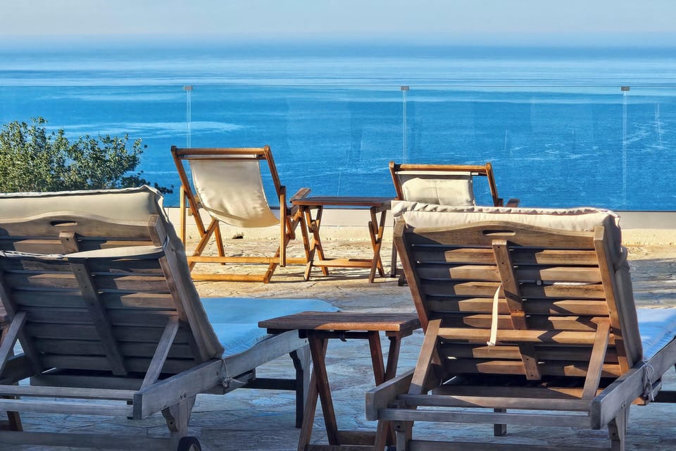 Poolside loungers overlooking the sea, ideal for relaxing, sunbathing, and enjoying the view.