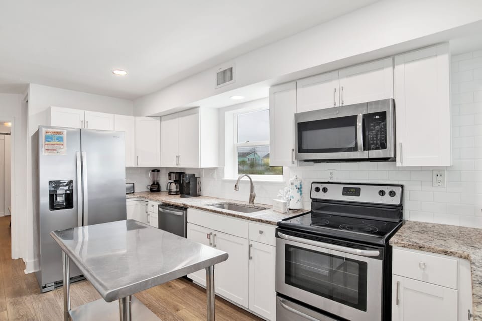 The kitchen features stone counters and stainless appliances