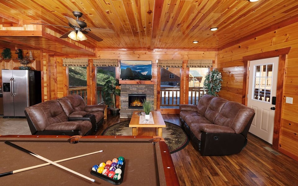 Spacious living area with pool table, fireplace, and cozy seating.