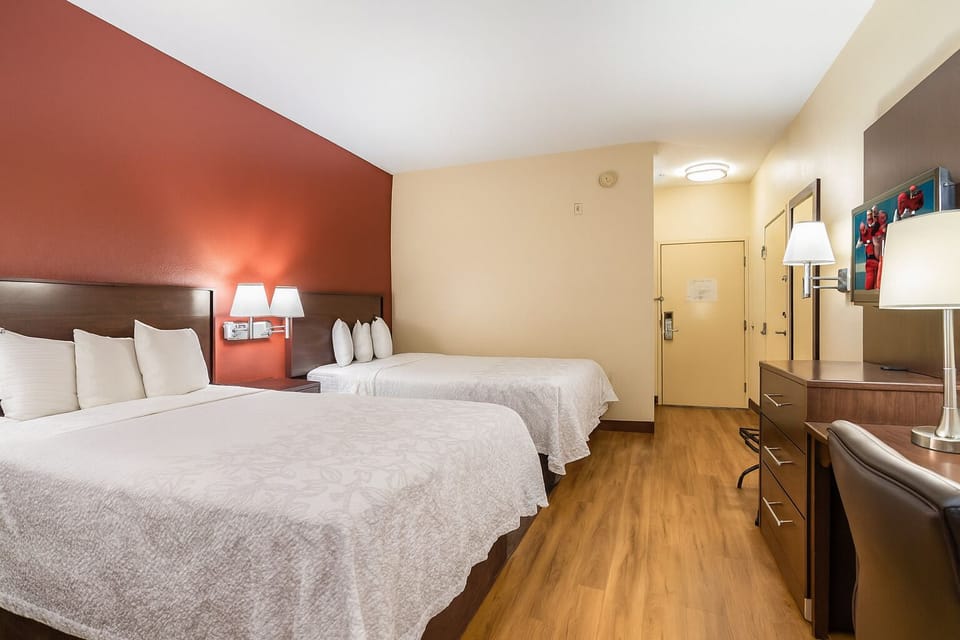 Unwind in a spacious double-queen room with warm lighting.