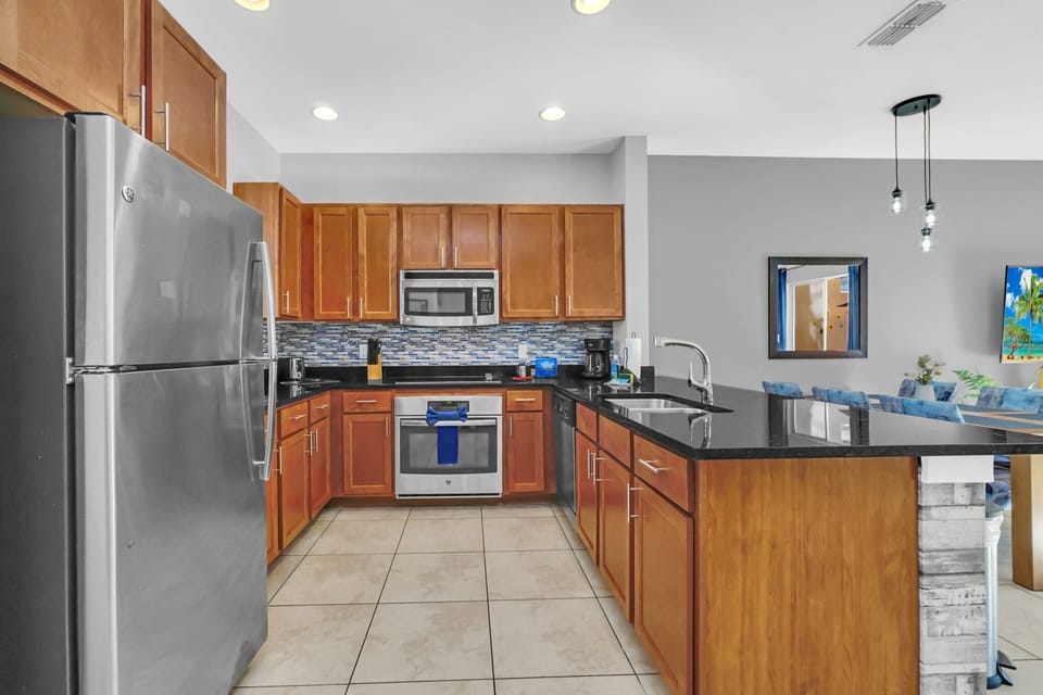 Spacious open kitchen with stainless appliances and solid surface countertops