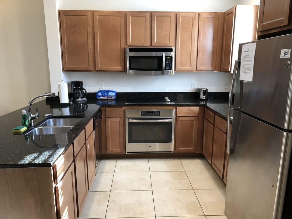 Spacious kitchen with solid surface countertops and stainless appliances
