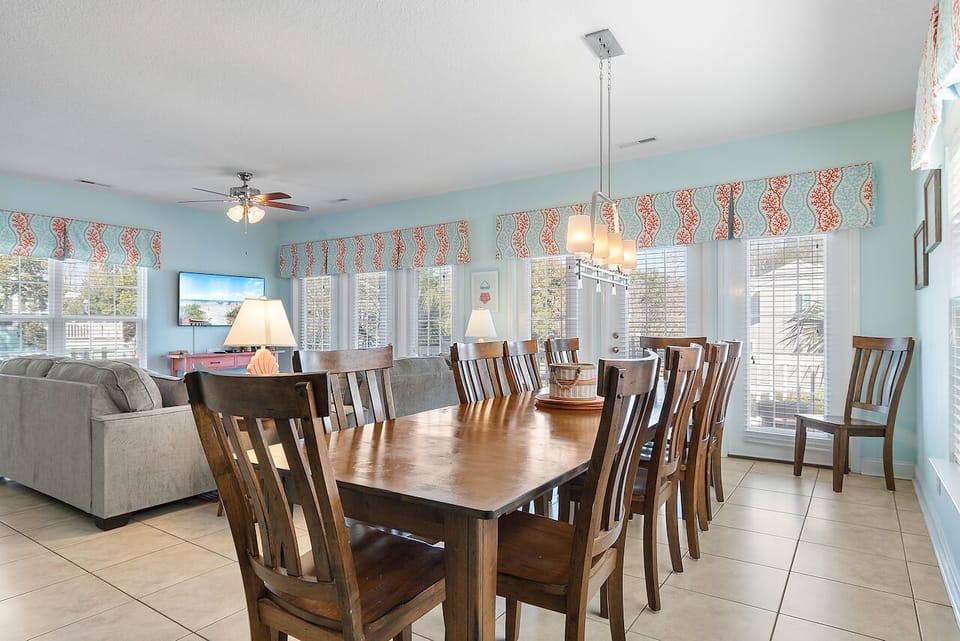 Your spacious dining room features a generous table for family meals, with soft turquoise walls and cheerful coral accents creating warmth.