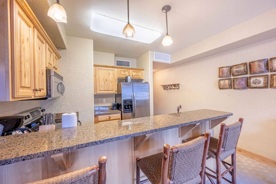 Breakfast bar with seating for three (3) and knotty pine cabinetry.