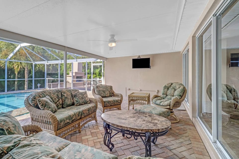 A wall mounted TV with Xfinity "Ultimate" cable package is located under the covered area on the lanai.