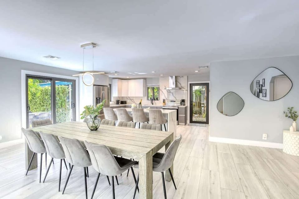 House 1 kitchen/dining area with Quartz waterfall island and 10-seat dining room table. 