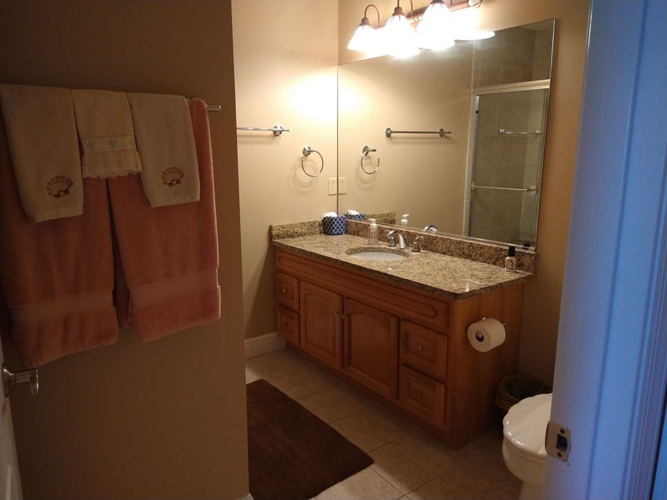 Master bathroom with lots of towel sets under the sink,Toiletries and starter TP