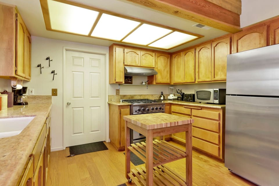 Fully equipped cabin kitchen with ample cabinetry, stove, fridge, microwave, and coffee maker—perfect for cooking meals, morning coffee, and feeling right at home on your stay.