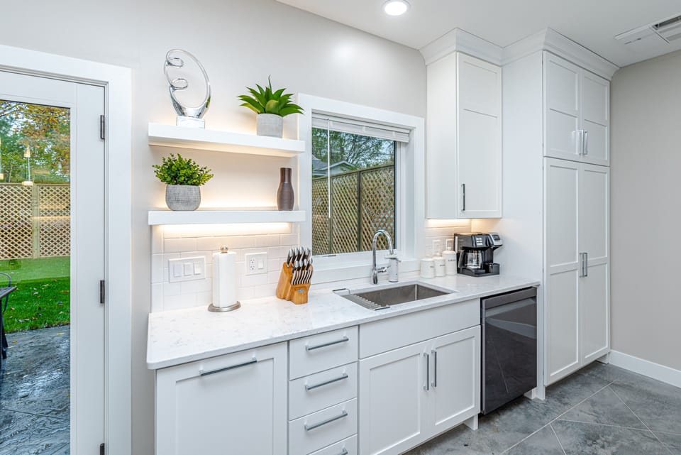 kitchen cupboard, smart dishwasher, sink with window out to courtyard & patio