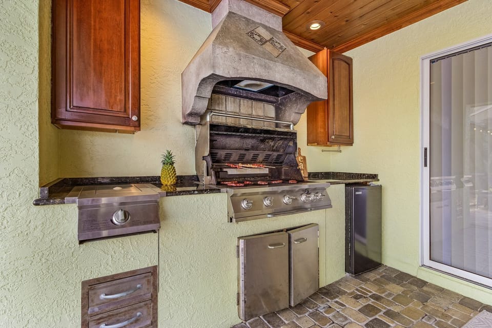 outdoor grill area with a mini fridge.