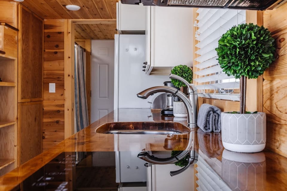 The kitchen is fully equipped with a refrigerator, freezer, microwave, cooktop, and sink with hot/cold water. Enjoy coffee from the coffee maker and ample counter space. Essentials include cookware, dishes, utensils, and plenty of storage cabinets.