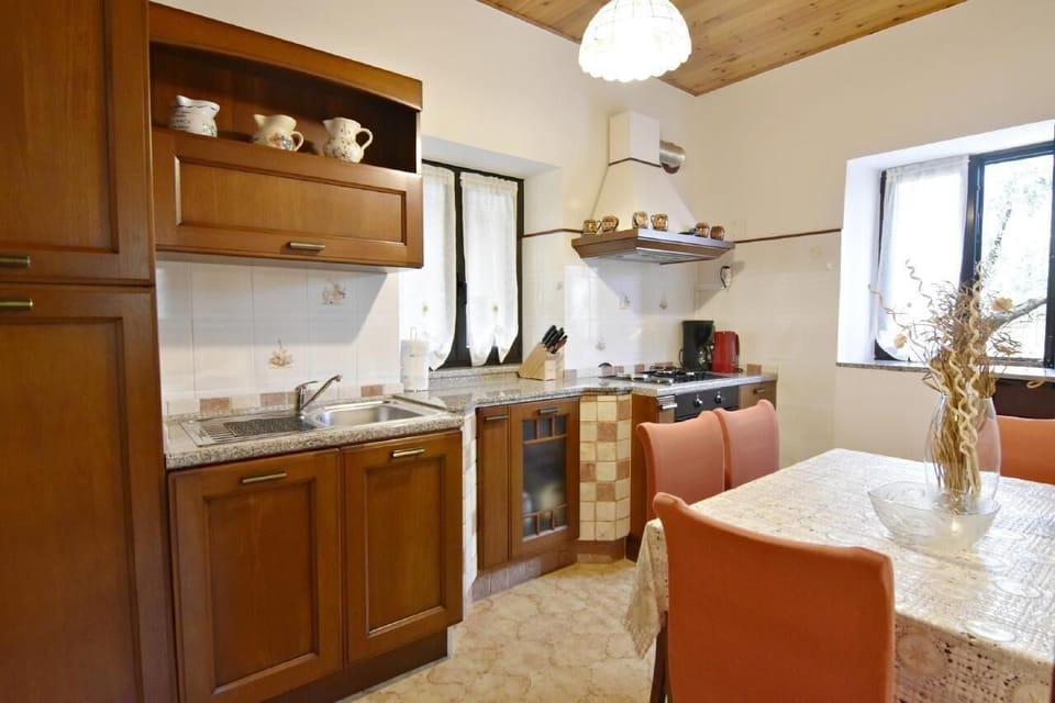 The kitchen equipped with an oven, stove, coffee machine, kettle and dining table.