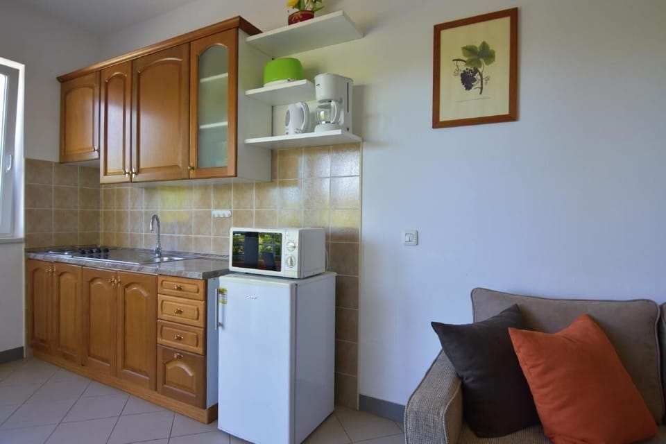 The kitchen with microwave, coffee maker, kettle, toaster, refrigerator