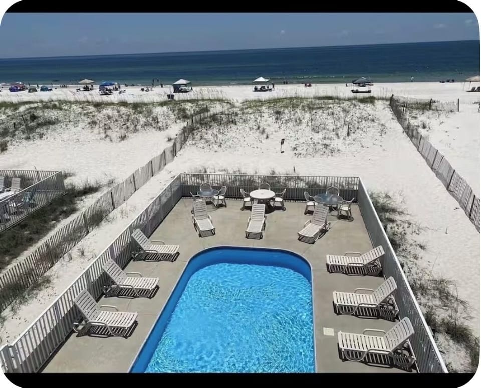 Big pool with beach behind it
