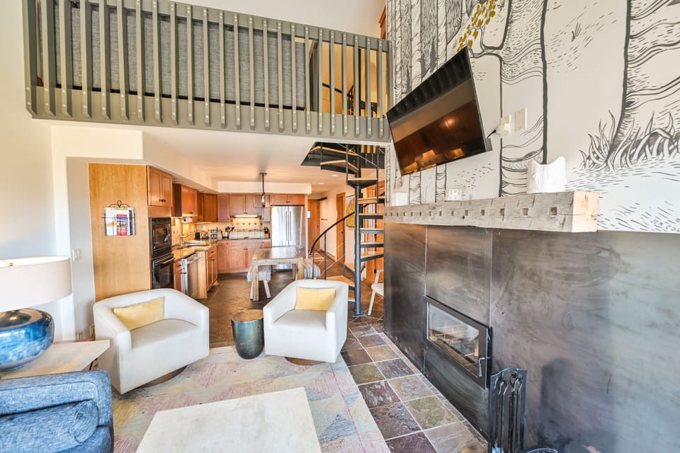 Cozy living room with wood burning fireplace and large screen TV