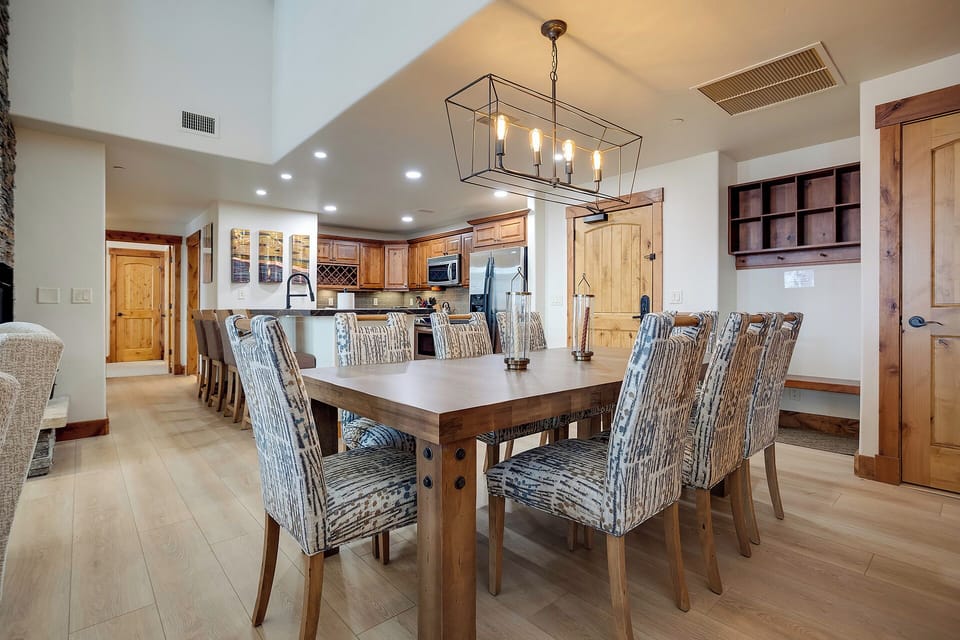 Gather around your spacious dining table where warm wood tones and elegant lighting create the perfect atmosphere for memorable meals together.