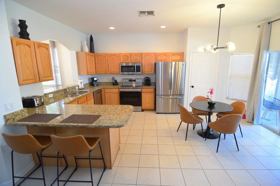 Fully equipped open-plan kitchen with breakfast nook and breakfast bar