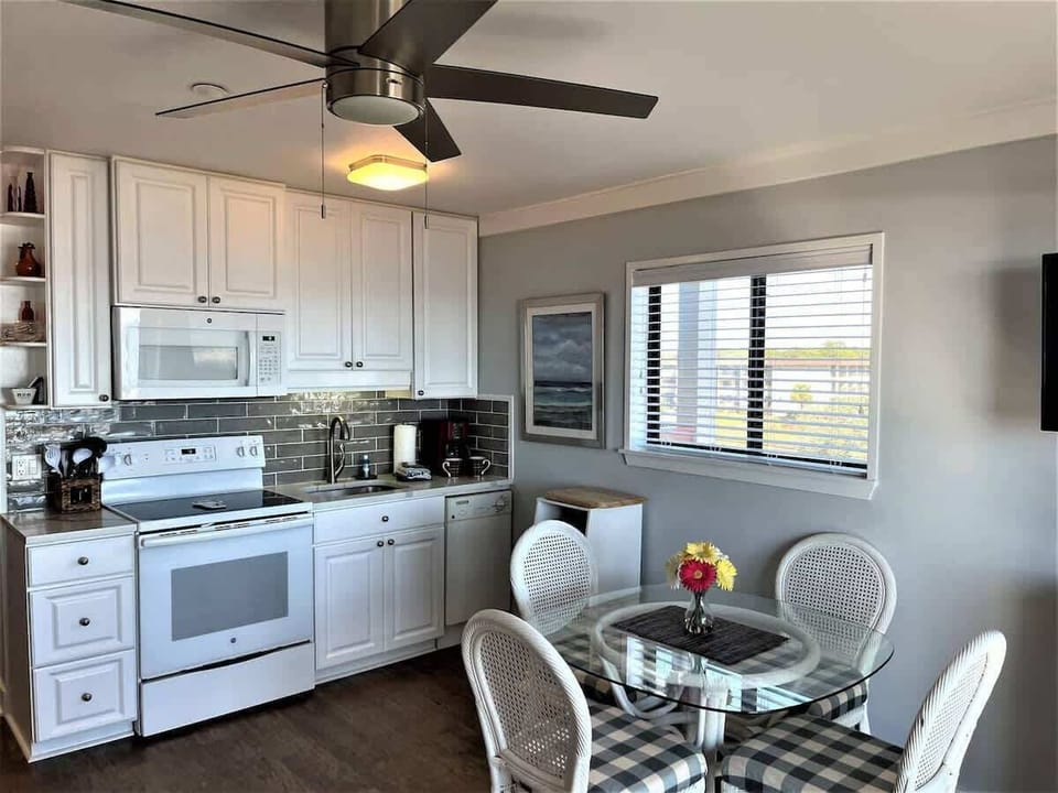 A fully equipped, clean white kitchen with modern appliances and a functional layout.