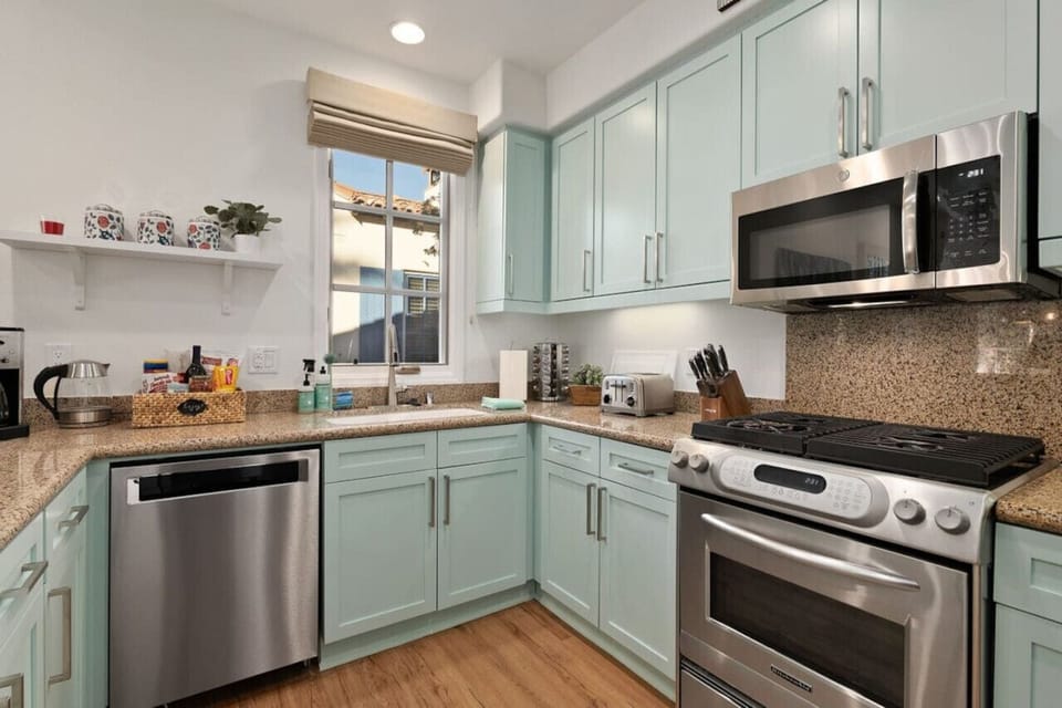 The kitchen was updated and reimagined with luxury vinyl plank flooring, colorful shaker cabinetry, granite counter tops, Kitchenaid dishwasher and gas range + GE Microwave.