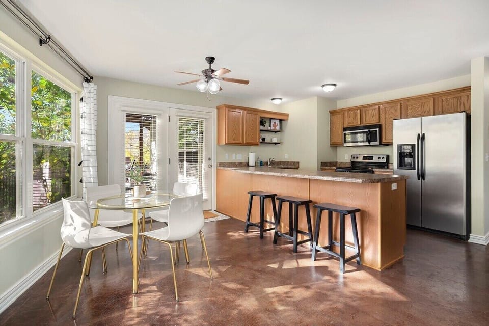 This kitchen features high-end amenities and appliances, a large bar with seating for 3 and double doors leading to the backyard.