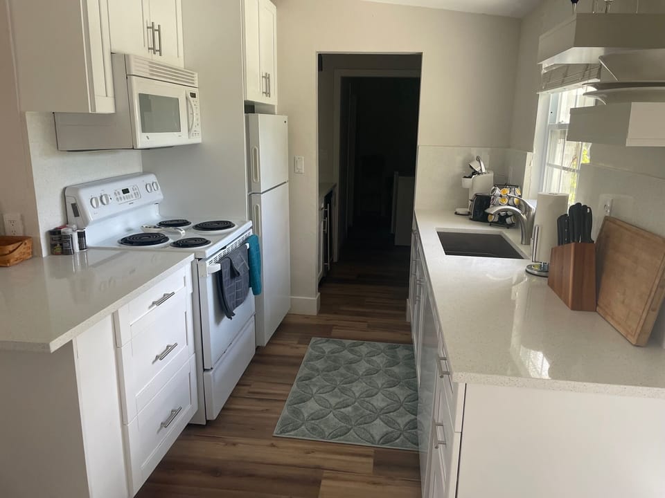 Through the kitchen to the pantry with wine fridge and onto laundry room