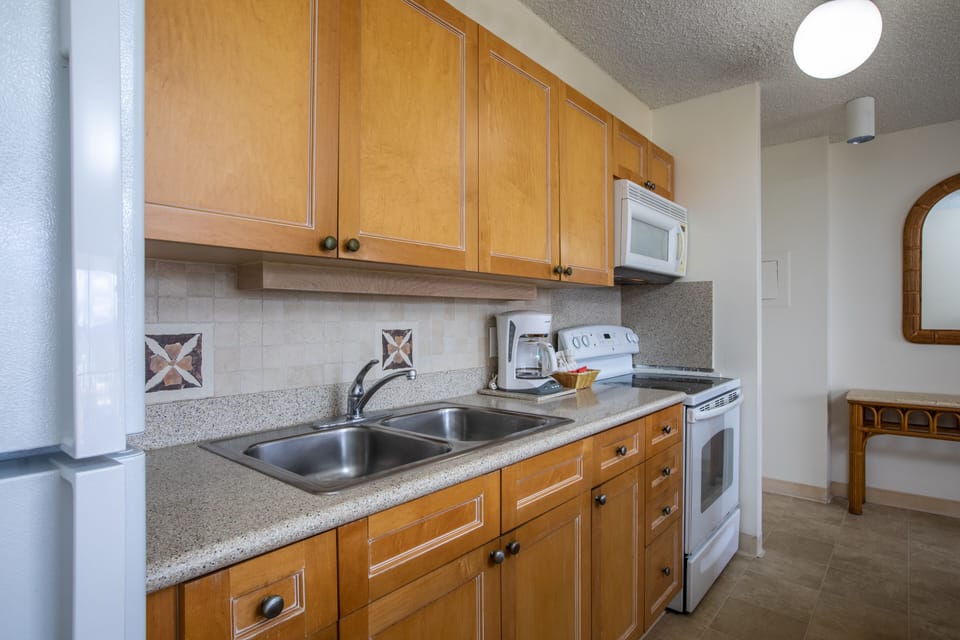 Your well-equipped kitchen features granite countertops, stainless steel double sinks, modern appliances, and warm wood cabinetry—everything needed to prepare meals just the way you like them.