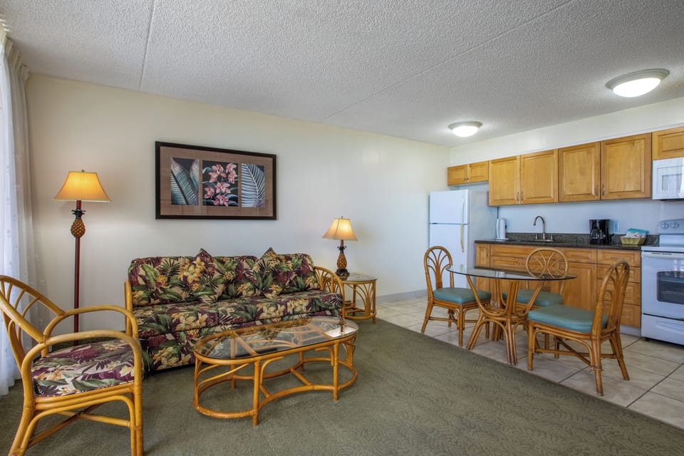 Step into your inviting open-concept retreat where tropical charm meets home comfort. Relax on the cozy floral sofa, whip up meals in your fully equipped kitchen, and gather around the dining table to plan your next adventure.