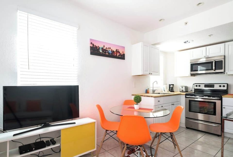 Cook and dine with ease in this modern Airbnb kitchen with stainless steel appliances and a cozy dining nook.

