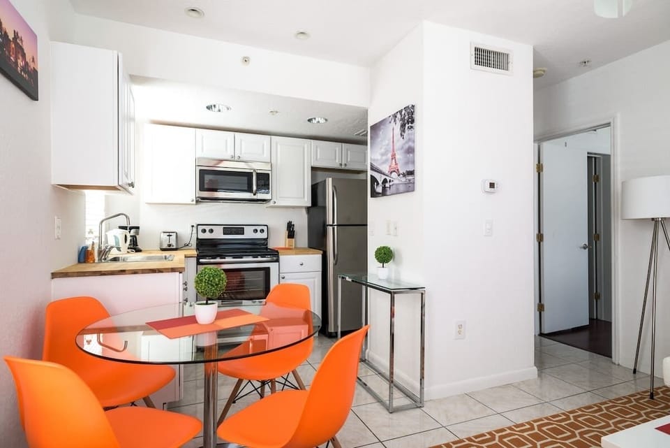 Whip up meals in this sleek Airbnb kitchen with stainless steel appliances and cozy dining space—great for extended stays.

