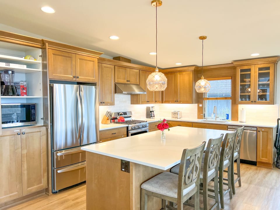 Kitchen, island with 4 chairs. The microwave is in the cabinet
