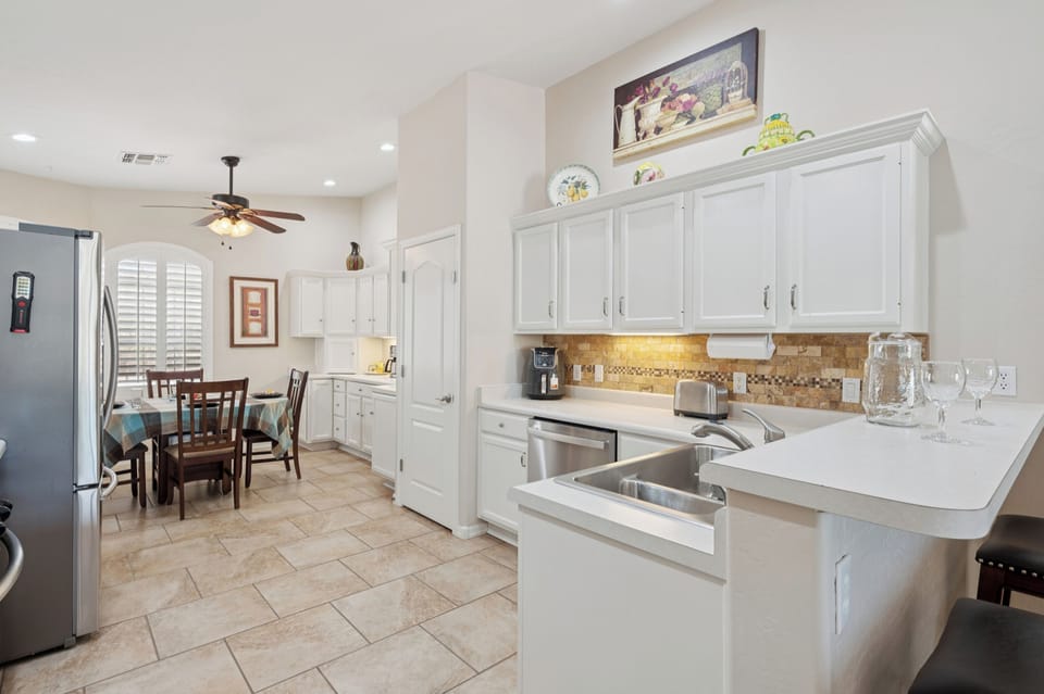 Bright and beautifully decorated featuring sleek white finishes and under-cabinet lighting for a modern touch