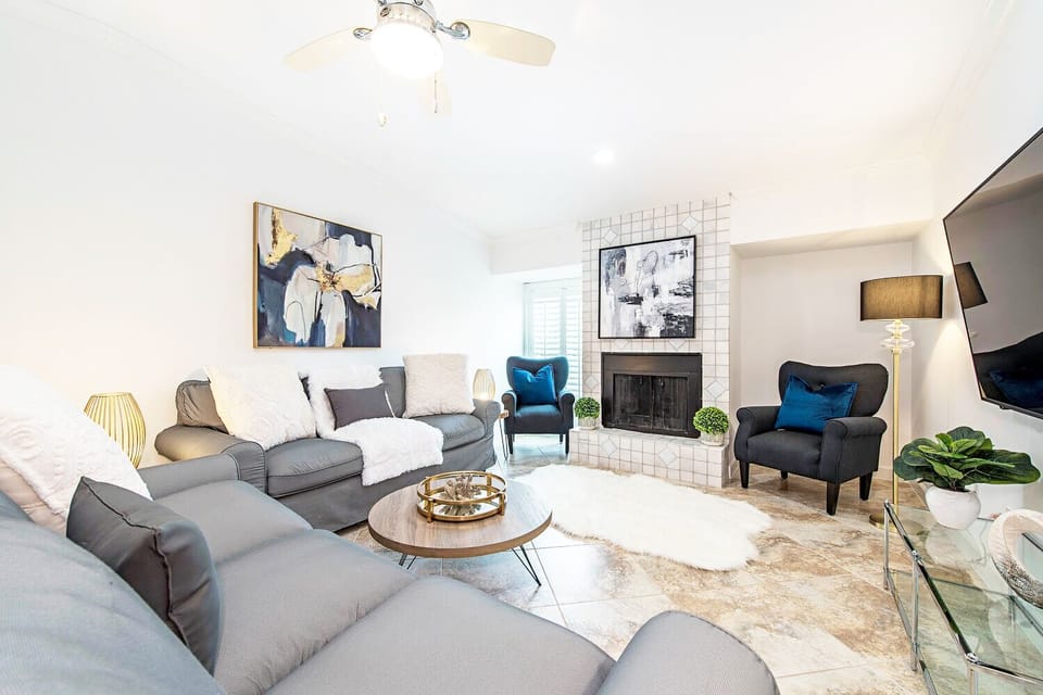 The living room features two overstuffed comfortable couches and 65 inch TV