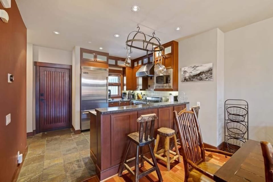 Open kitchen with updated stainless appliances.