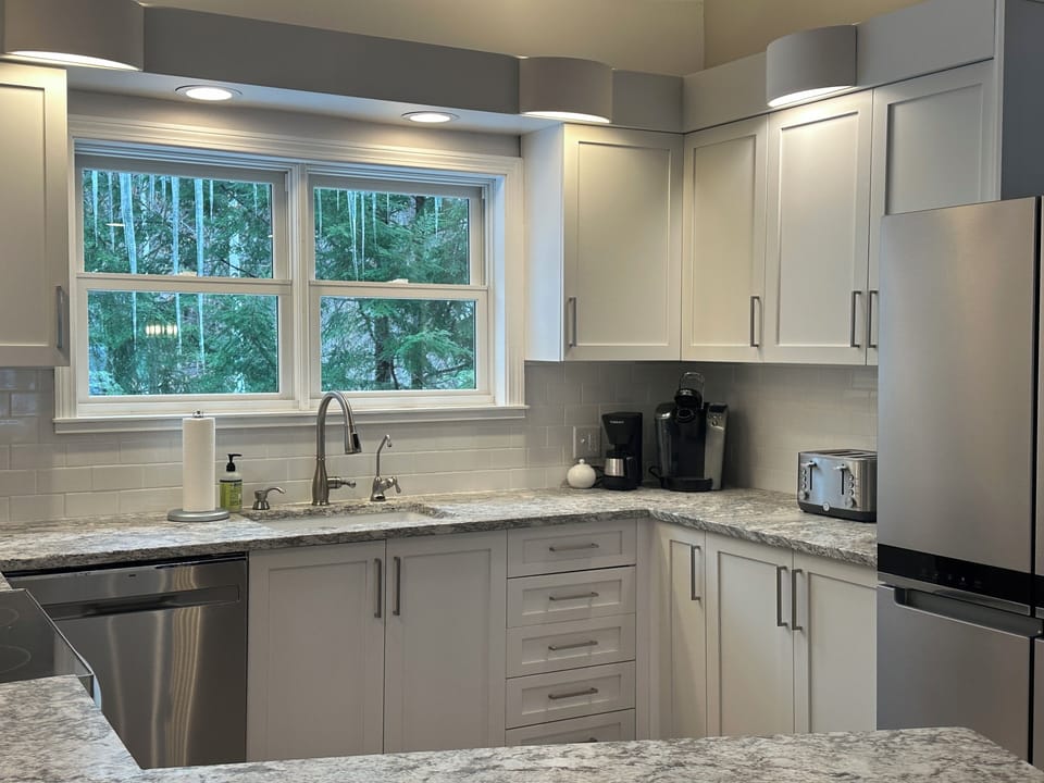 Modern appliances and filtered drinking water at kitchen sink