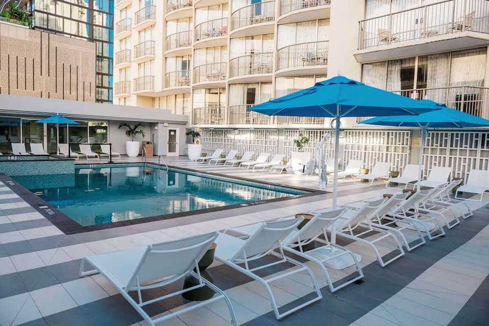 Unwind poolside on sleek loungers under bright umbrellas.